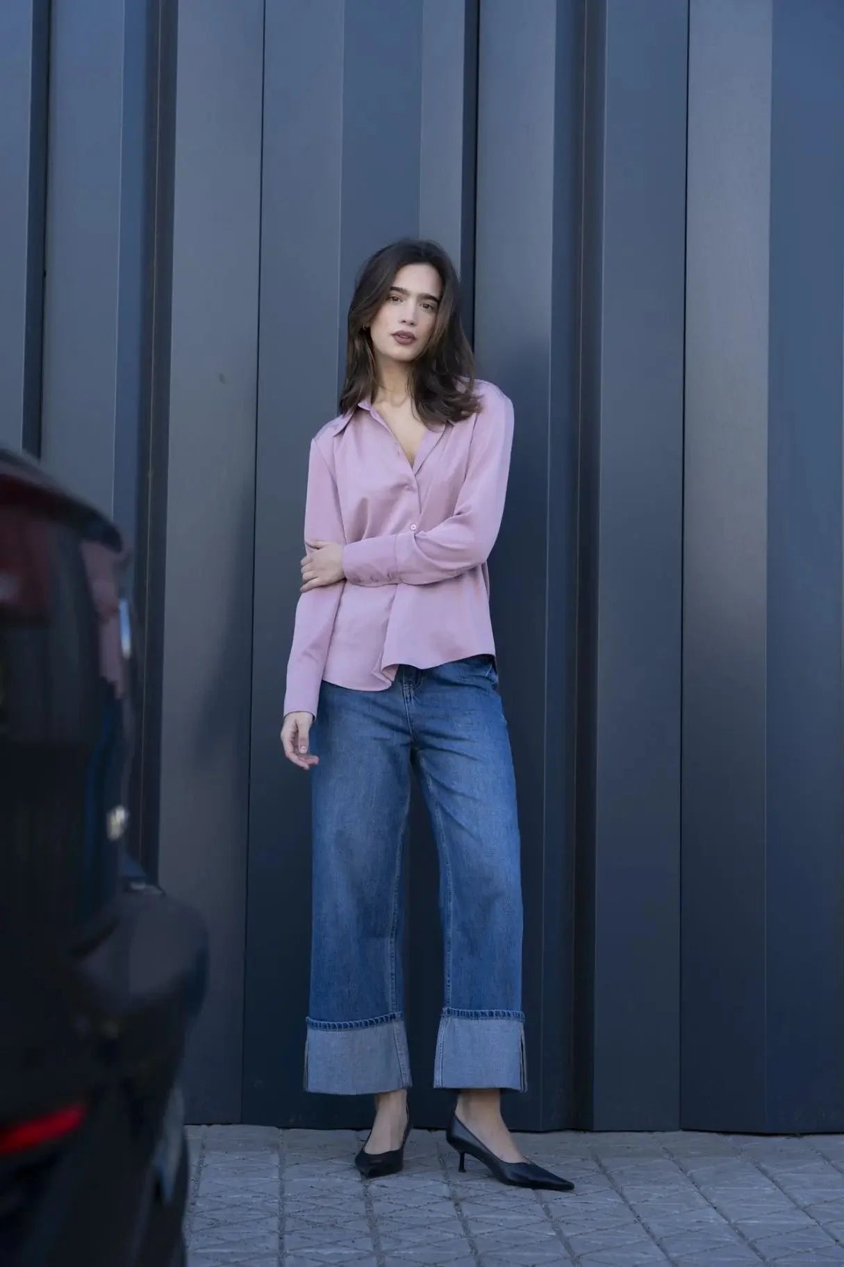 Modèle posant avec la chemise fluide femme lilas à col pointu, associée à un pantalon denim pour une allure moderne.