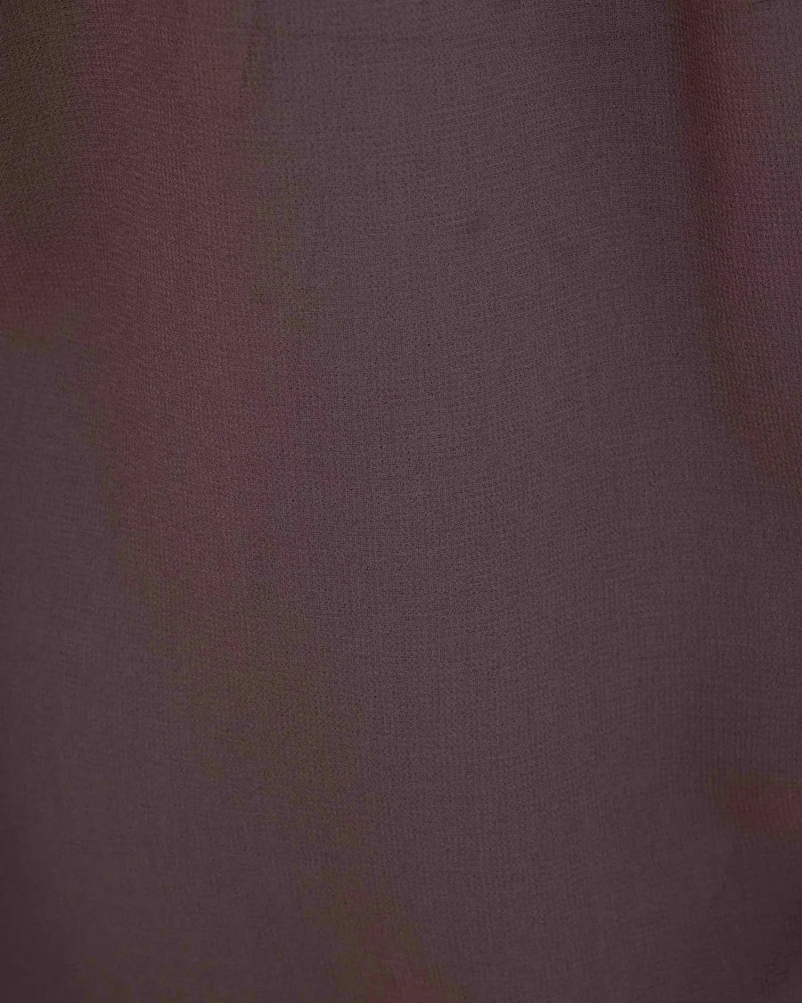 Détail du tissu d'une chemise col lavallière fluide marron transparent, illustrant la légèreté et la transparence du matériau.