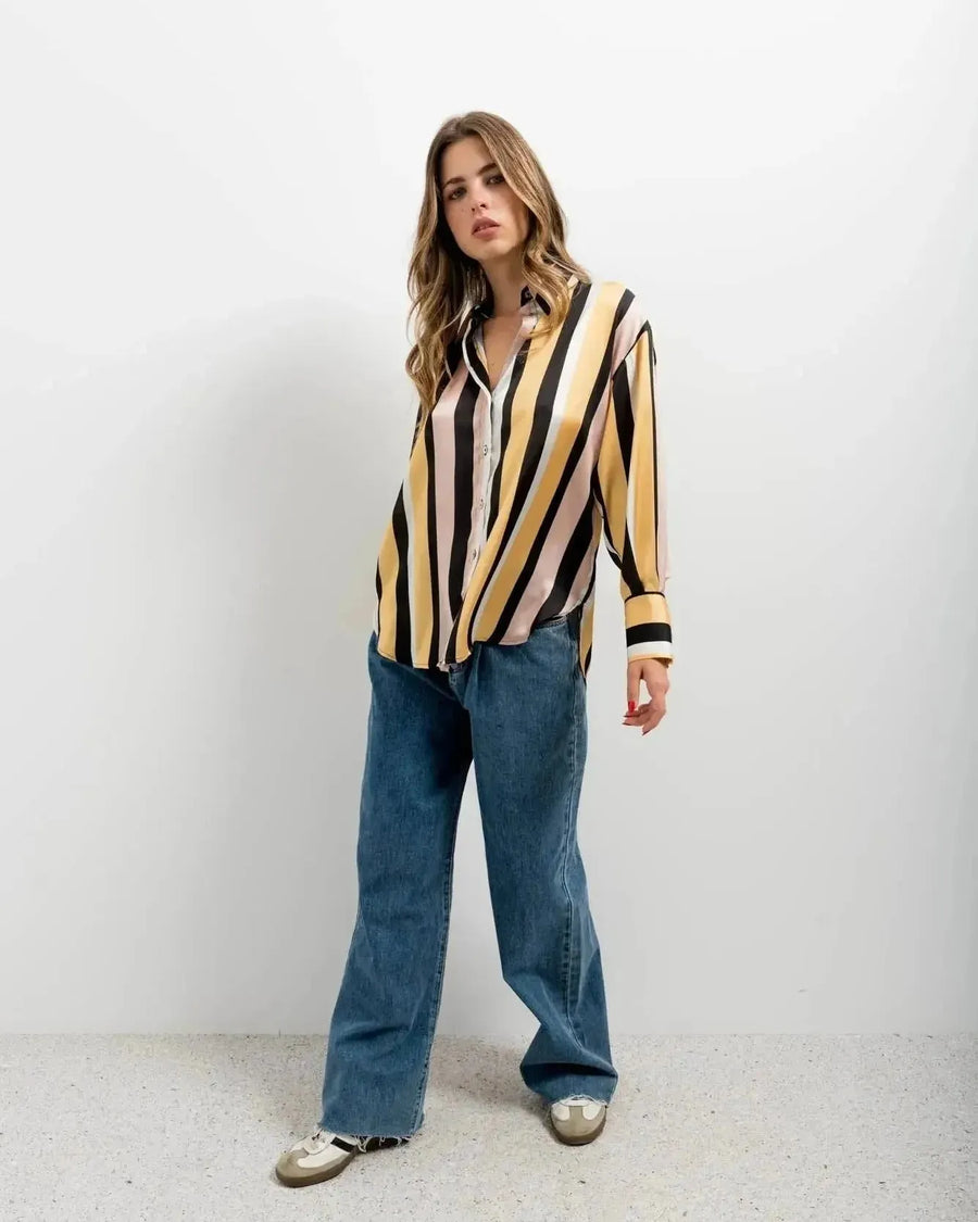 Femme exhibant une chemise imprimée animal à rayures diagonales, associée à un jean décontracté pour un look casual. Chemise rayure femme.