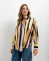 Femme portant une chemise imprimée animal à rayures diagonales, style moderne avec rayures jaune et noir, idéale pour un look tendance. Chemise rayure femme.