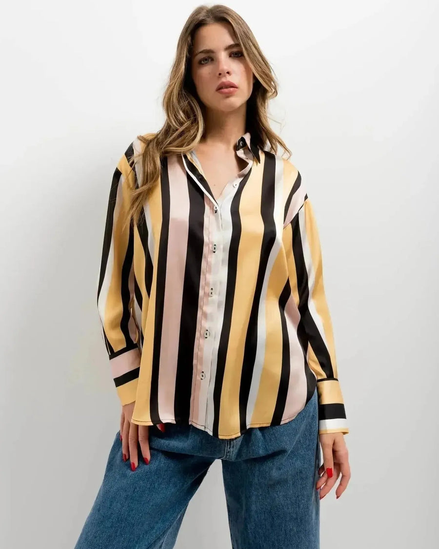 Femme en portrait avec une chemise imprimée animal à rayures diagonales dans des tons de jaune et noir, parfaite pour un style chic. Chemise rayure femme.