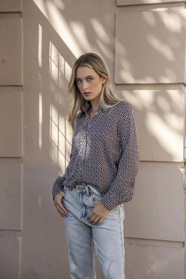 Gros plan sur une femme affichant une chemise noir et blanc imprimée animal, parfaite pour un look chic et décontracté.