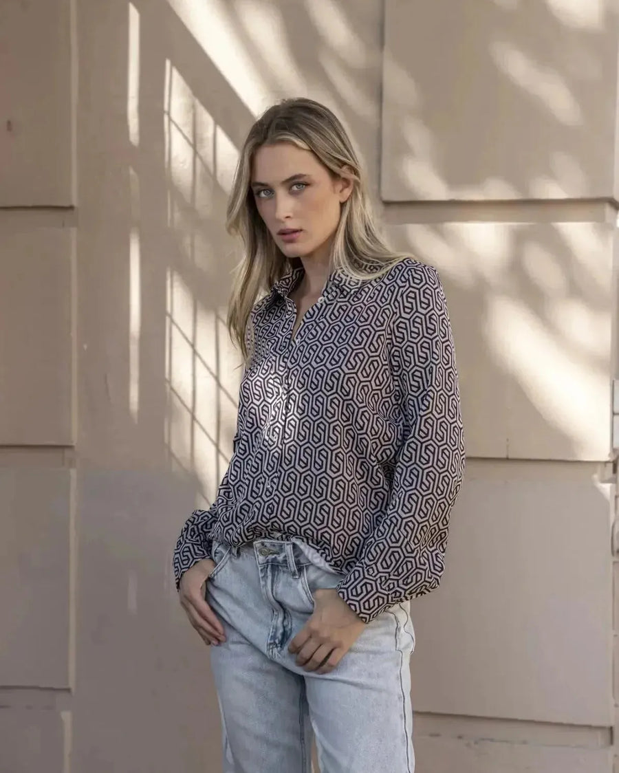 Gros plan sur une femme affichant une chemise noir et blanc imprimée animal, parfaite pour un look chic et décontracté.
