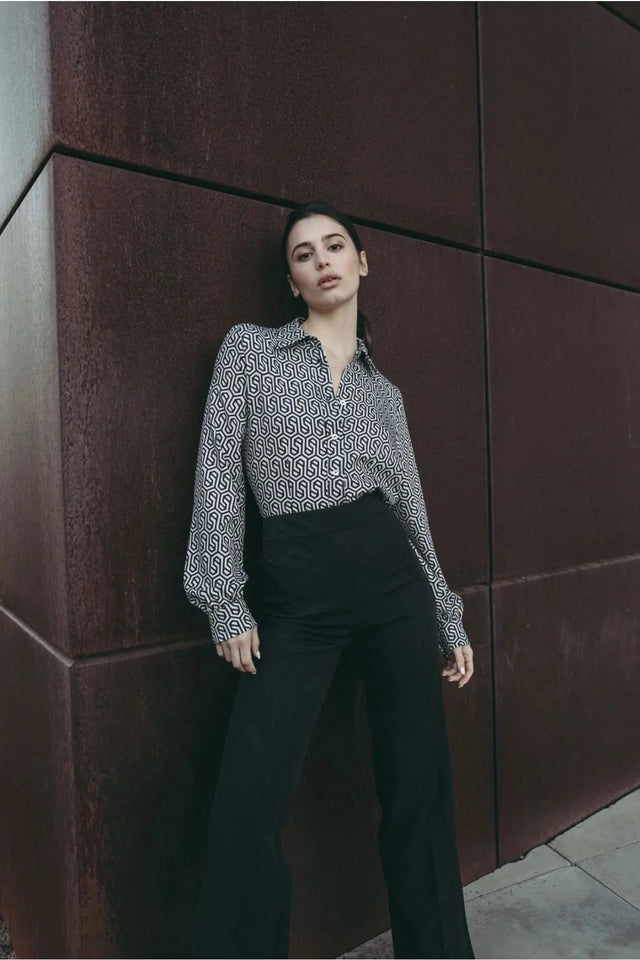 Femme élégamment habillée en chemise noir et blanc imprimée animal, incarnant une esthétique à la fois audacieuse et raffinée.