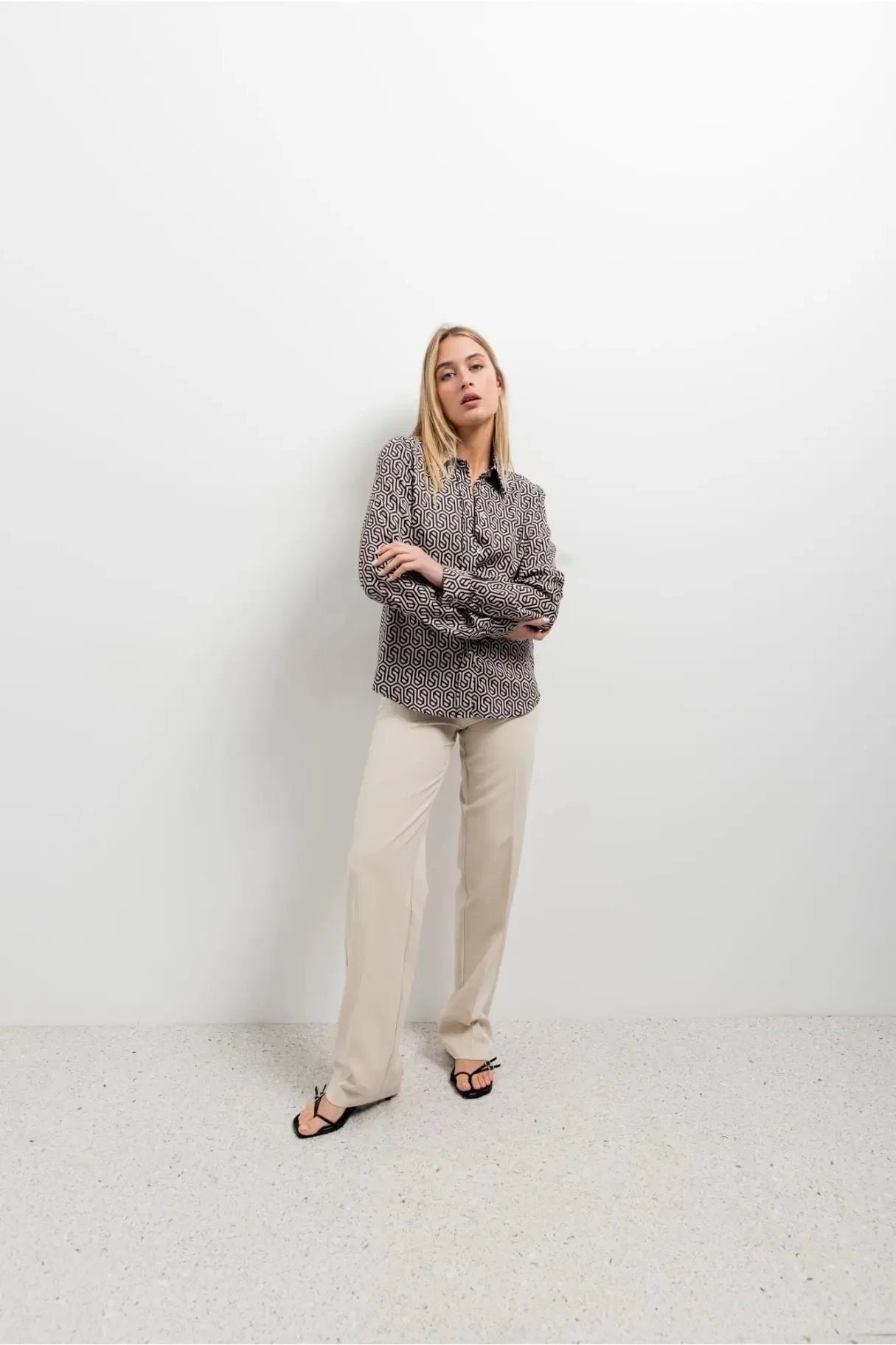 Modèle en chemise noir et blanc imprimée animal, avec un style à la fois décontracté et sophistiqué, parfait pour toute occasion.