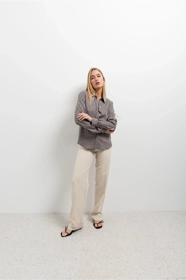 Modèle en chemise noir et blanc imprimée animal, avec un style à la fois décontracté et sophistiqué, parfait pour toute occasion.