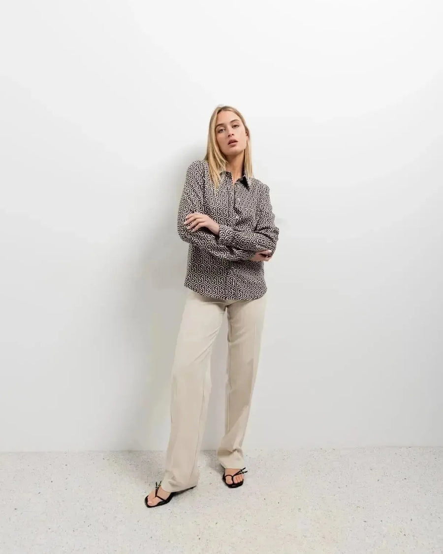Modèle en chemise noir et blanc imprimée animal, avec un style à la fois décontracté et sophistiqué, parfait pour toute occasion.
