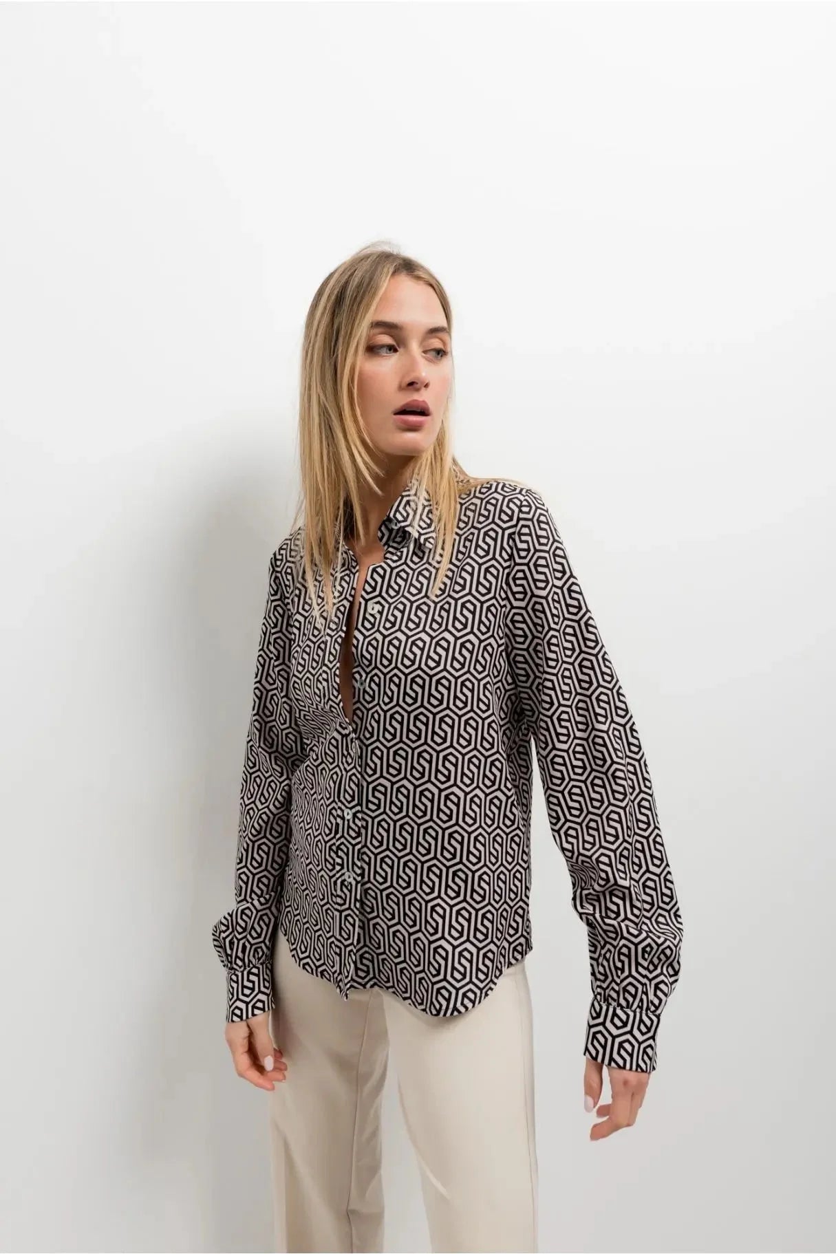 Femme portant une chemise noir et blanc imprimée animal au design unique, accentuant son allure élégante et moderne.