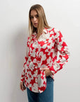 Détail de la chemise fleurie femme rouge et blanche en satin, mettant en avant son design chic et ses manches ajustées, parfaite pour toutes occasions.