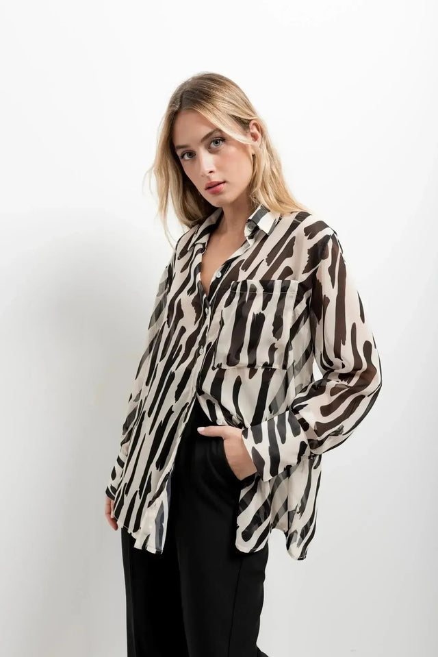Chemise Transparente Femme Motif Zèbre Noir et Beige, Fluide et Élégante, affichant son motif abstrait sur un mannequin, parfaite pour une tenue tendance.