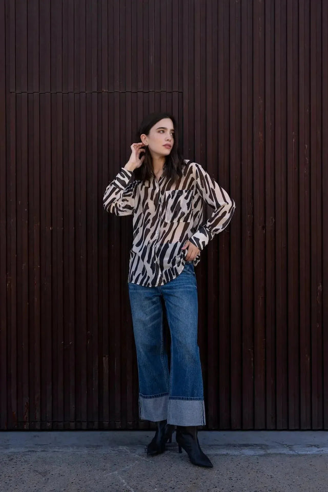 Chemise Transparente Femme Motif Zèbre Noir et Beige, Fluide et Élégante, portée avec un jean, mettant en avant sa versatilité pour différentes occasions.
