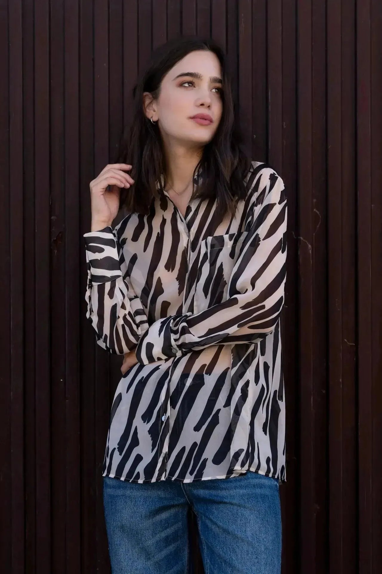Chemise Transparente Femme Motif Zèbre Noir et Beige, Fluide et Élégante, montrée sur un modèle dans un environnement extérieur, reflétant un style casual.