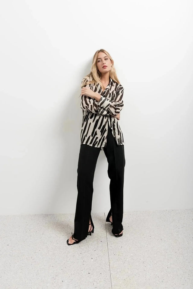 Chemise Transparente Femme Motif Zèbre Noir et Beige, Fluide et Élégante, portée par un modèle en pose décontractée, idéale pour des looks chics.