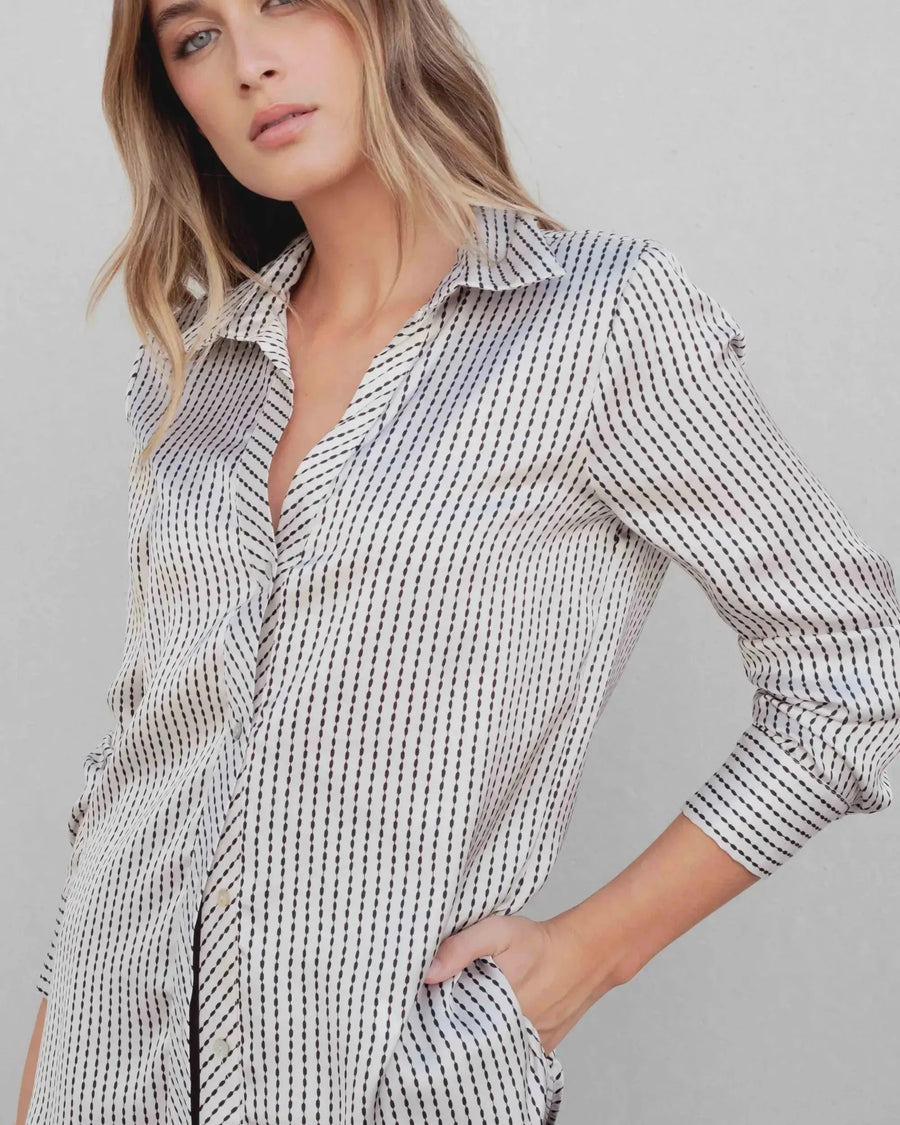Femme stylée avec une chemise satin rayée, parfaite pour des looks casual et chics, présentant la tendance de la chemise en satin femme.