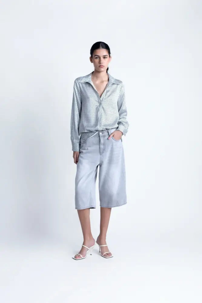 Chemise satin rayée pour une tenue casual avec culottes en denim et sandales blanches