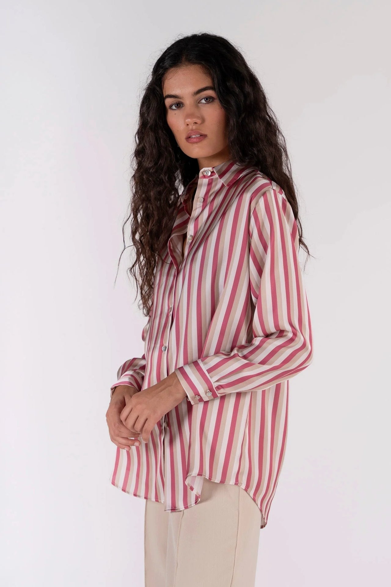 Chemisier satin femme chic à rayures verticales, couleur rose et beige, mise en avant sur un mannequin, avec une coupe fluide dans un cadre sobre.