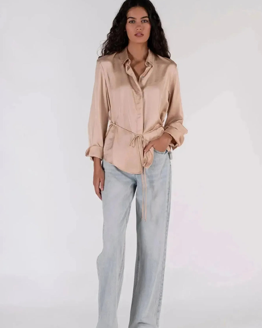 Chemise Satinée au Toucher Luxueux, un chemisier satin femme stylé présenté dans un ensemble décontracté.