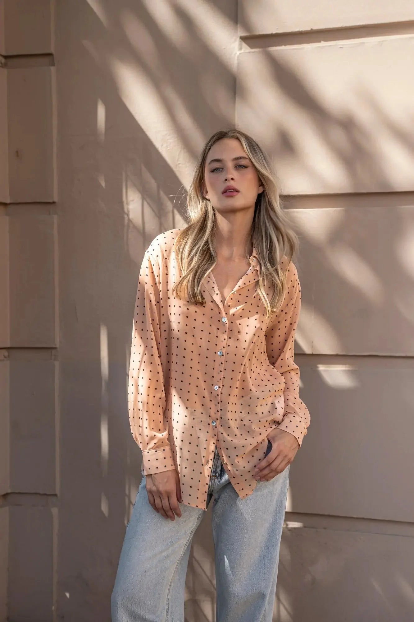 Chemise semi-transparente à pois noirs en tissu peach avec manches longues et boutons