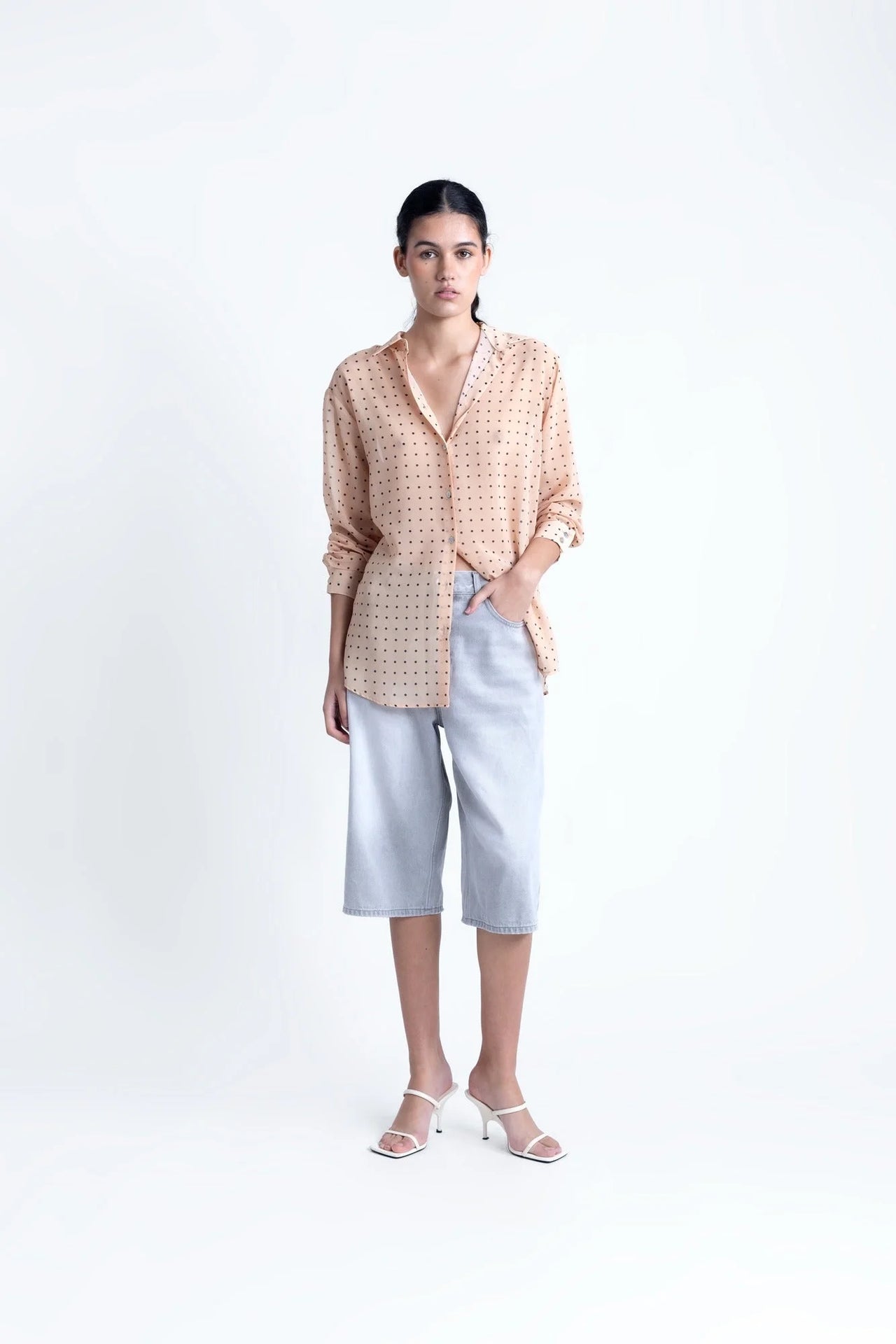 Chemise Transparente Femme À Pois Noirs – Blouse Fluide Chic Et Légère En Voile Nude, vue de face, associée à des shorts en jean, style décontracté.