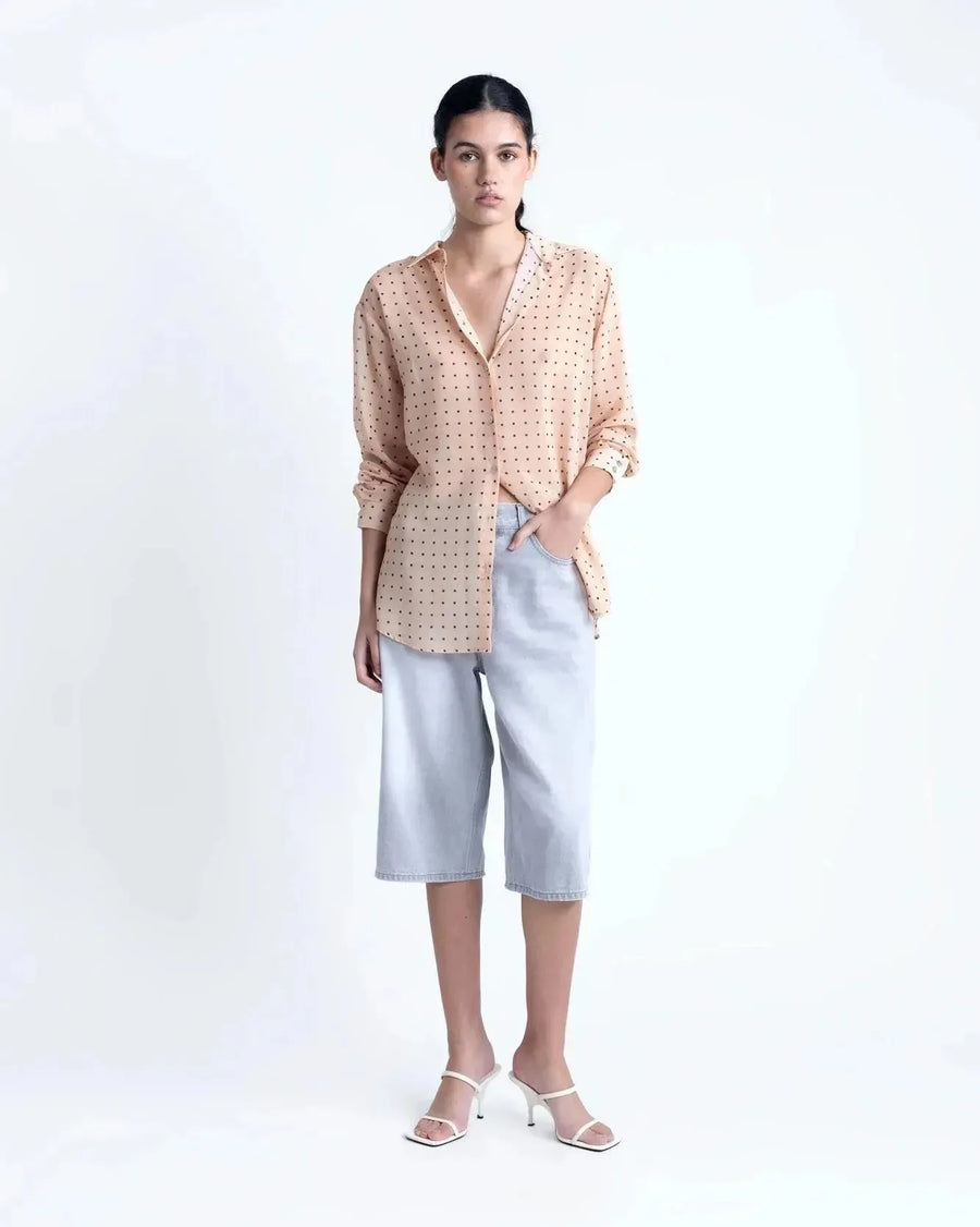 Chemise Transparente Femme À Pois Noirs – Blouse Fluide Chic Et Légère En Voile Nude, vue de face, associée à des shorts en jean, style décontracté.