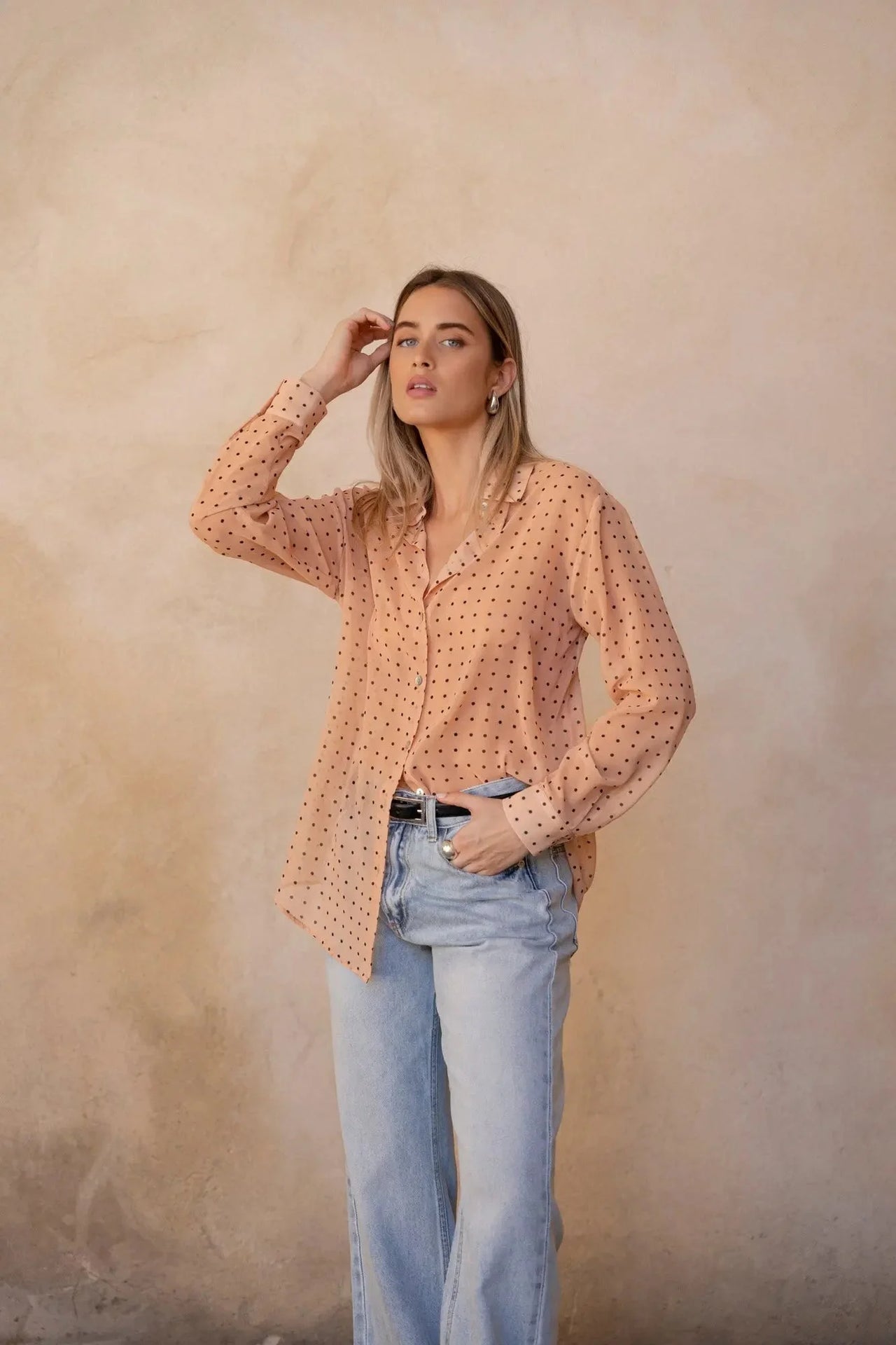 Chemise Transparente Femme À Pois Noirs – Blouse Fluide, montrant un modèle avec les cheveux détachés, style naturel et élégant.