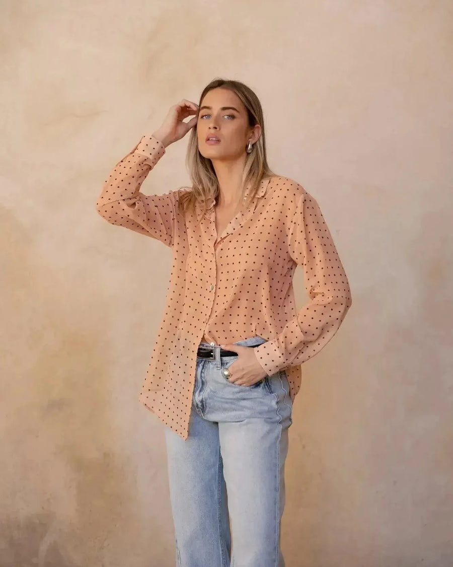 Chemise Transparente Femme À Pois Noirs – Blouse Fluide, montrant un modèle avec les cheveux détachés, style naturel et élégant.