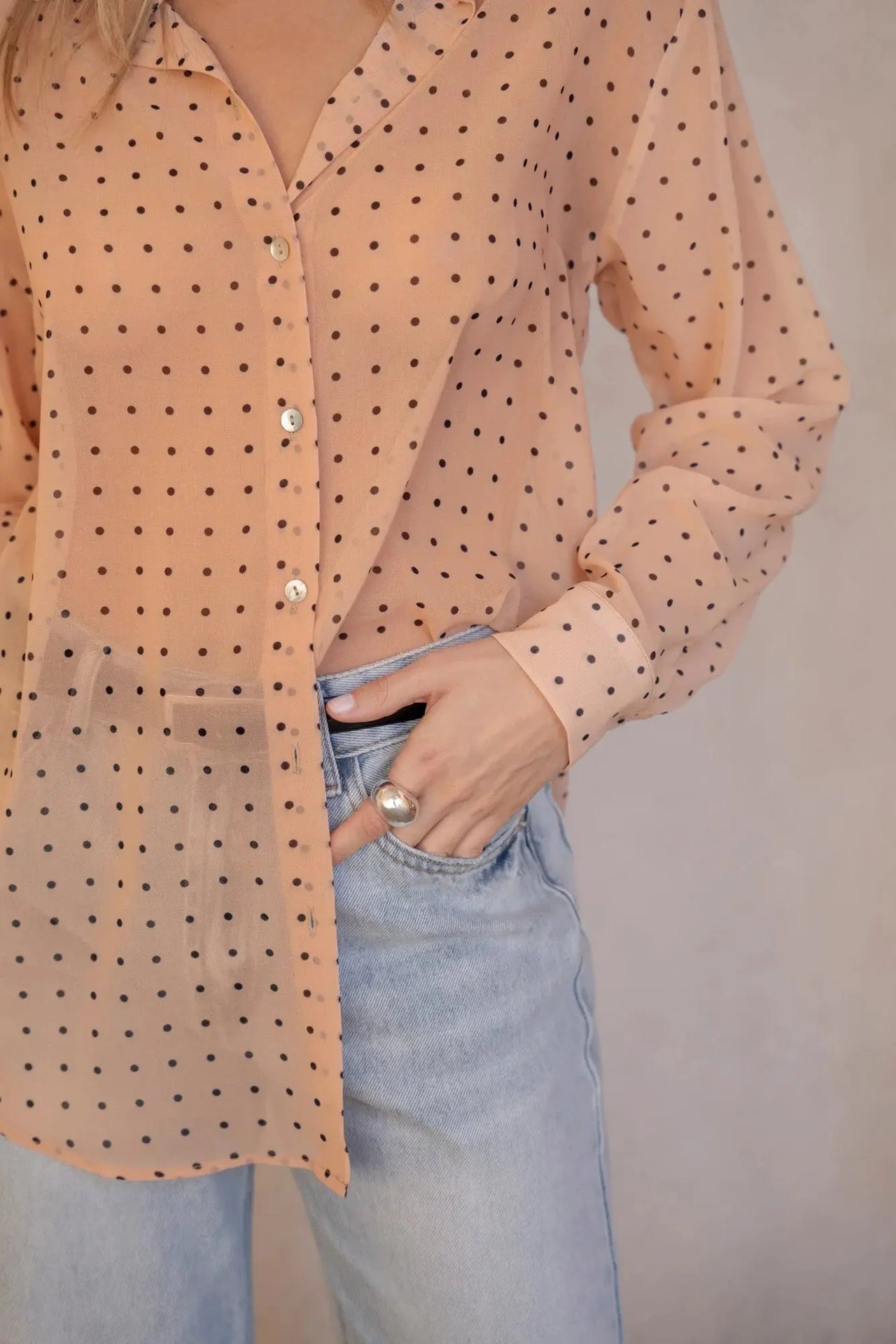 Détails de la Chemise Transparente Femme À Pois Noirs, focus sur le motif à pois noirs sur fond nude, idéale pour un look féminin.