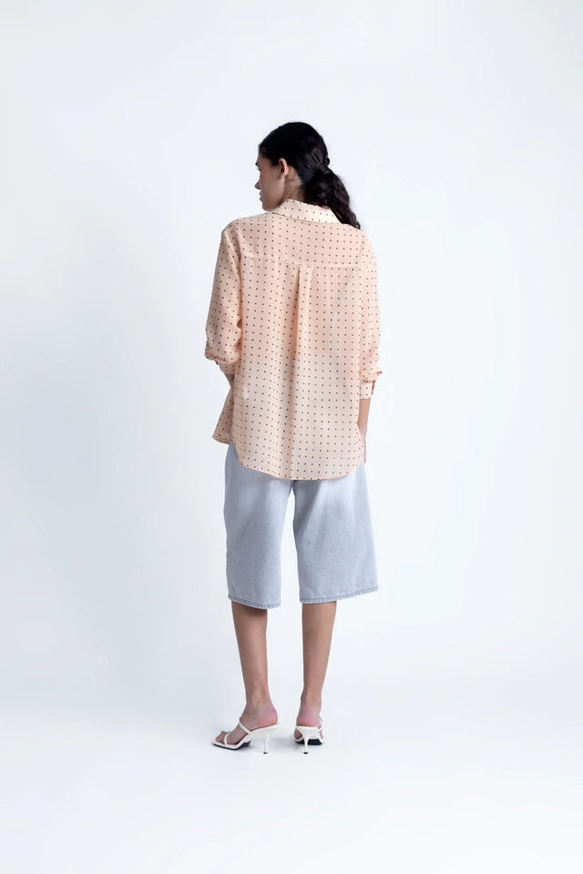 Vue arrière de la Chemise Transparente Femme À Pois Noirs, mettant en avant la coupe ample et légère de cette blouse chic.