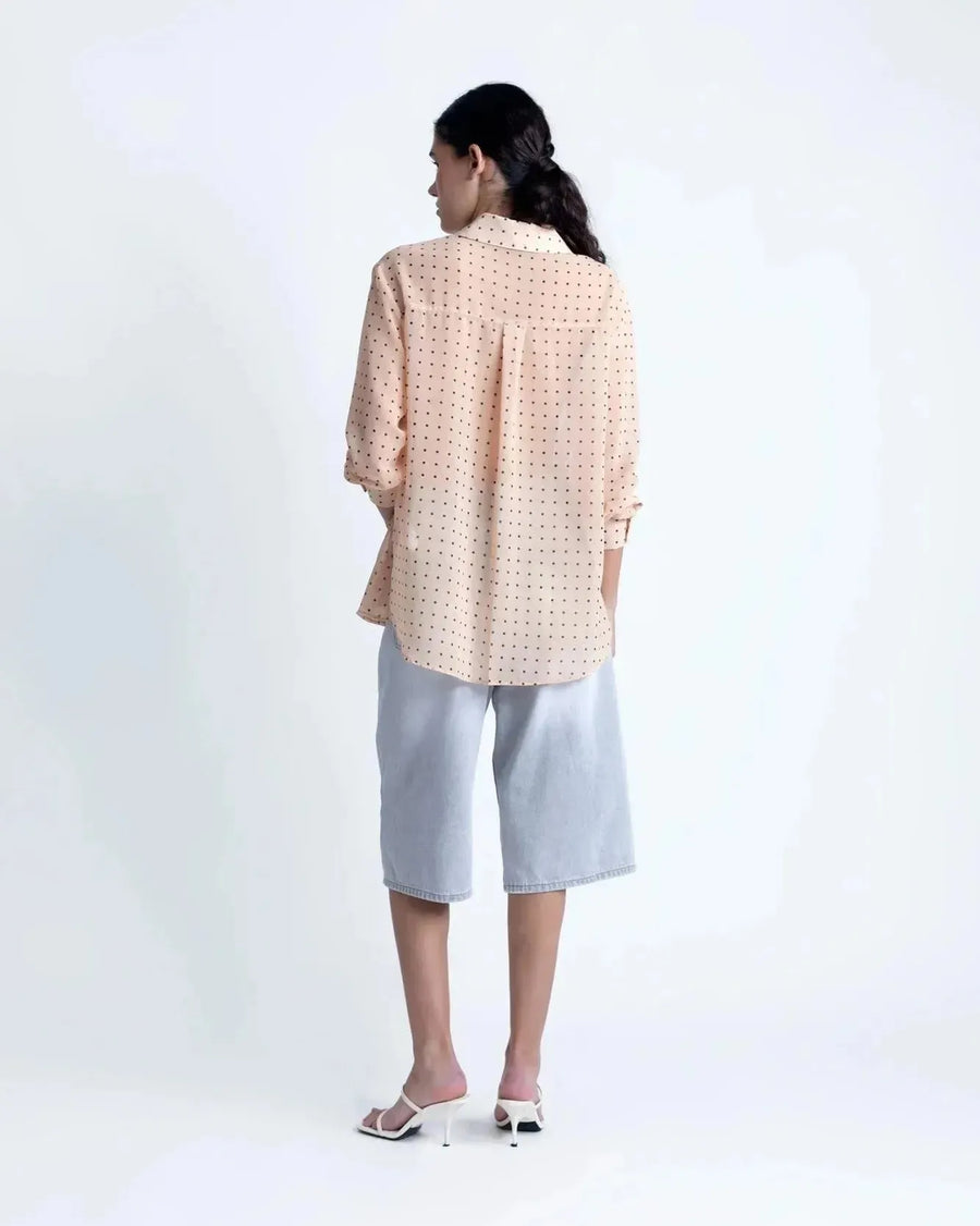 Vue arrière de la Chemise Transparente Femme À Pois Noirs, mettant en avant la coupe ample et légère de cette blouse chic.