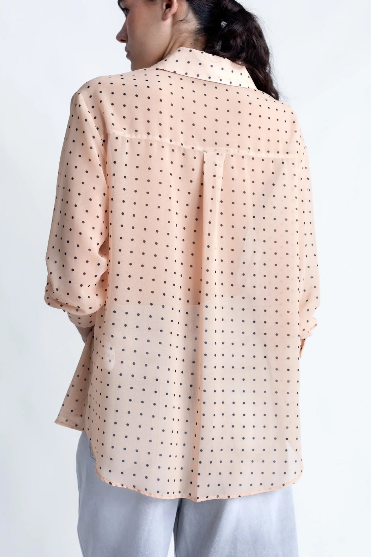Chemise Transparente Femme À Pois Noirs montrant les détails au dos, en couleur nude avec le motif à pois noirs, parfaite pour un look élégant.