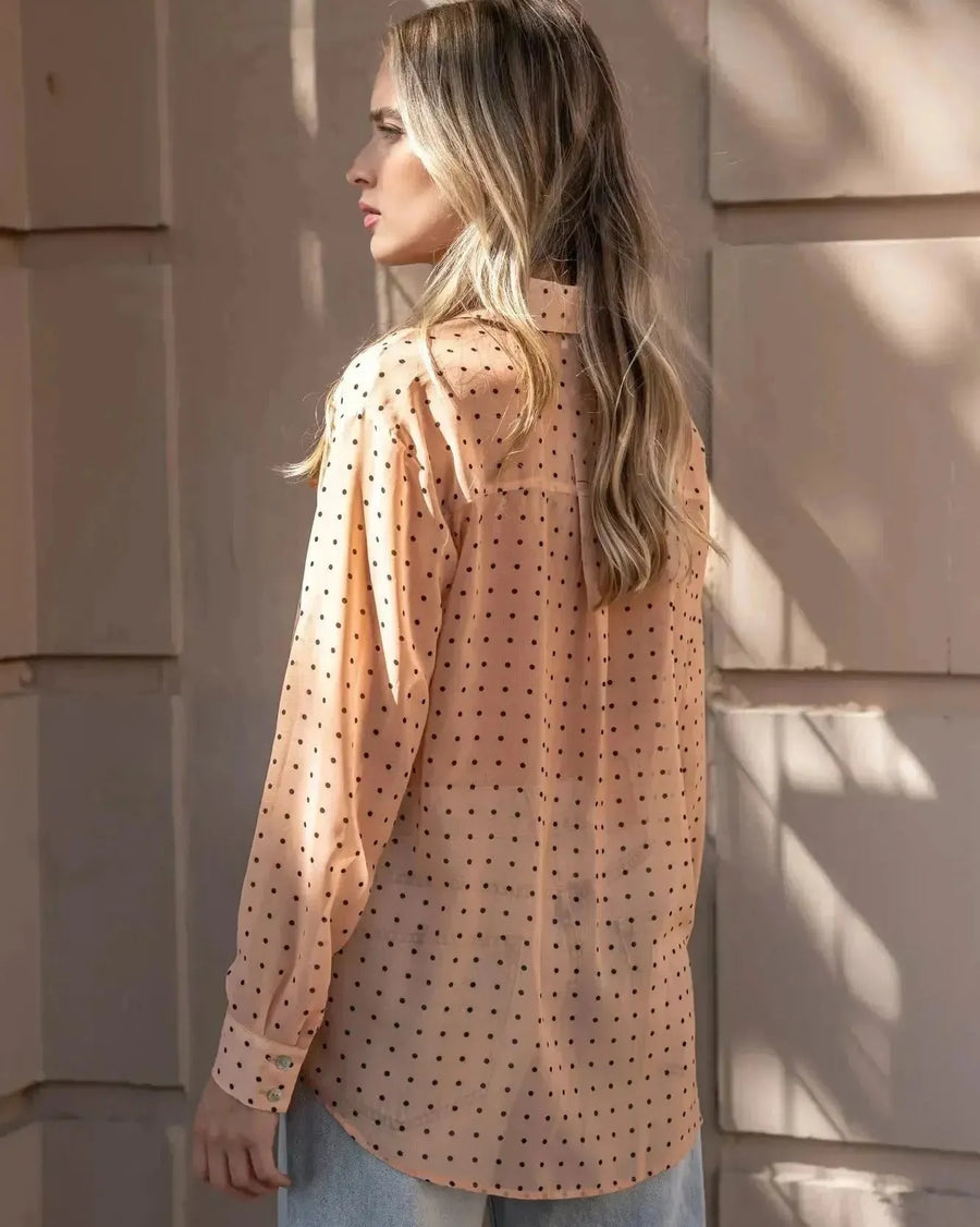 Profil de la Chemise Transparente Femme À Pois Noirs, vue de côté, soulignant la fluidité et le style élégant de cette blouse.