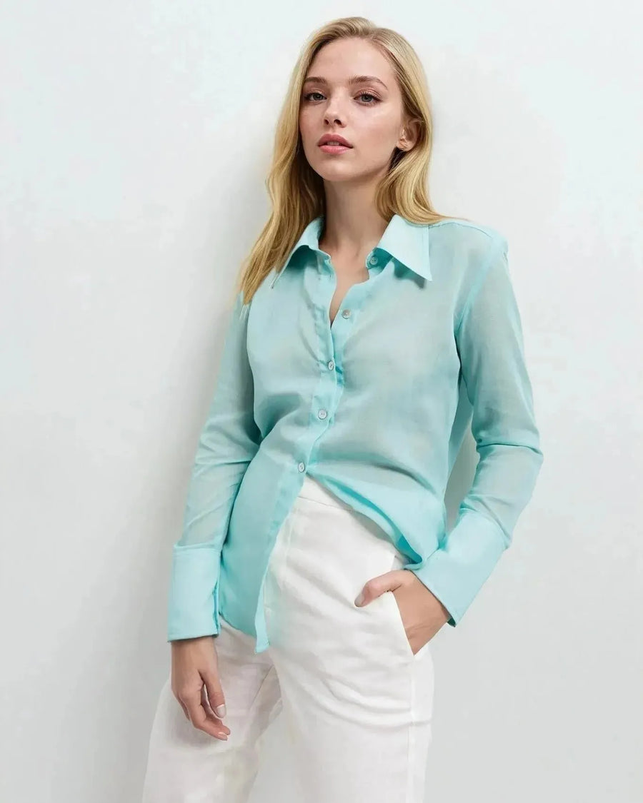Femme posant en chemise transparente pour femme, mettant en avant sa légèreté et son élégance.