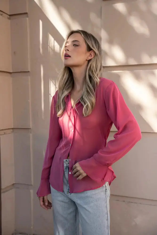 Femme portant une chemise transparente rose à manches longues et jeans bleu clair