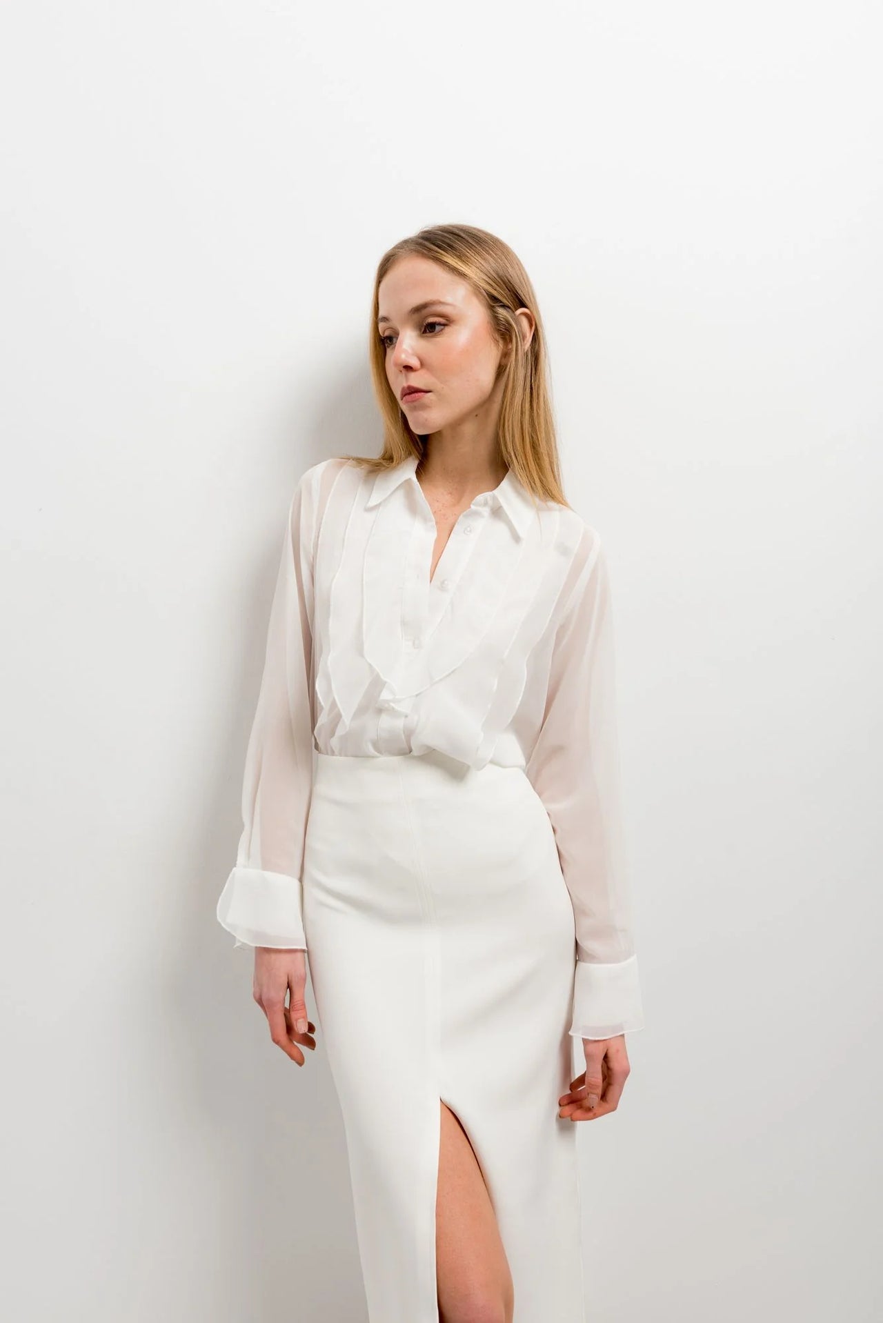 Femme en style décontracté avec une chemise à volants élégante en blanc, chic et polyvalente, mettant en avant les volants autour du col.