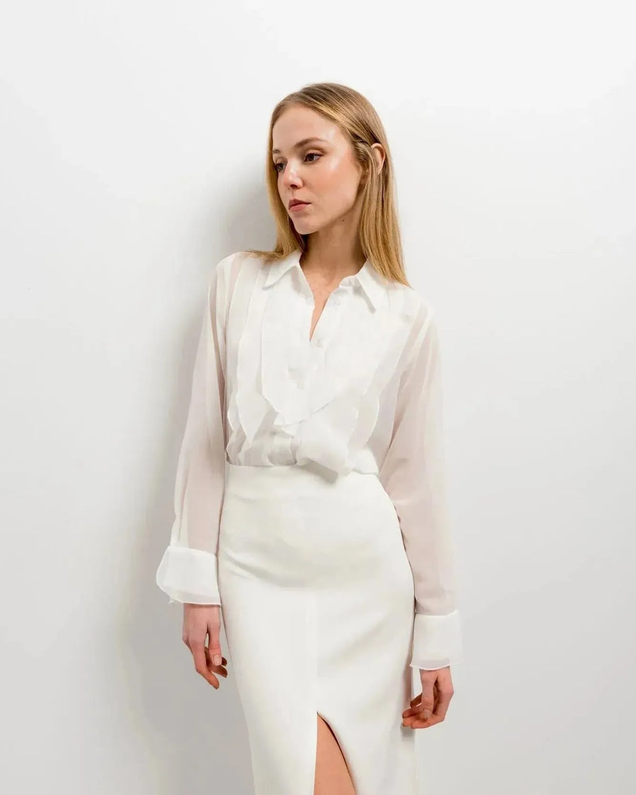 Femme en style décontracté avec une chemise à volants élégante en blanc, chic et polyvalente, mettant en avant les volants autour du col.