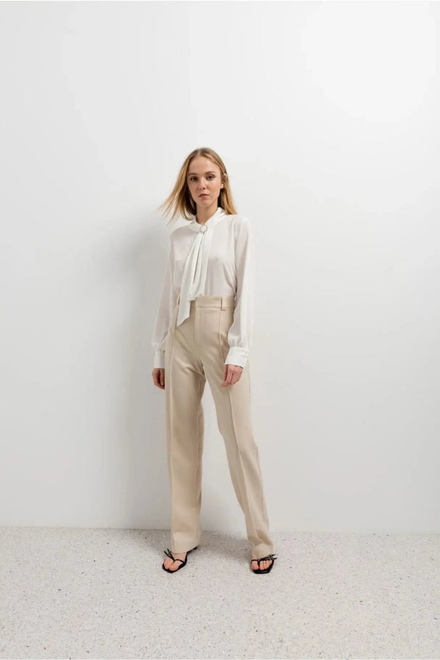 Chemisier blanc à col papillon avec haut col, bow tie, et pantalon large beige