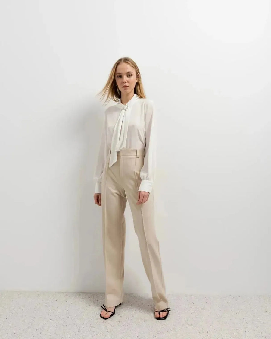 Chemisier blanc à col papillon avec haut col, bow tie, et pantalon large beige