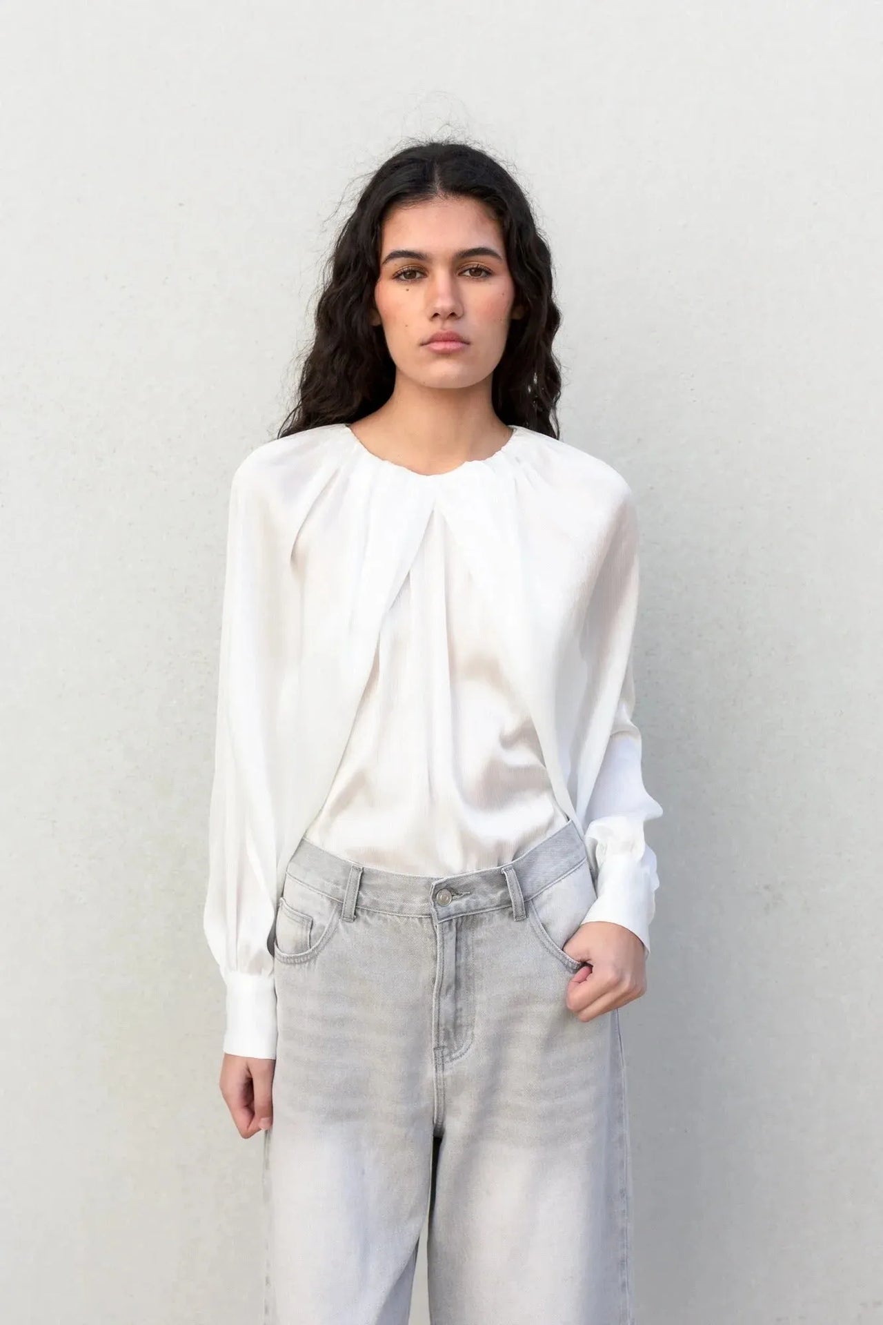Femme portant une blouse satin élégante, chic et confortable, montrant le devant de la blouse satin avec un style moderne.