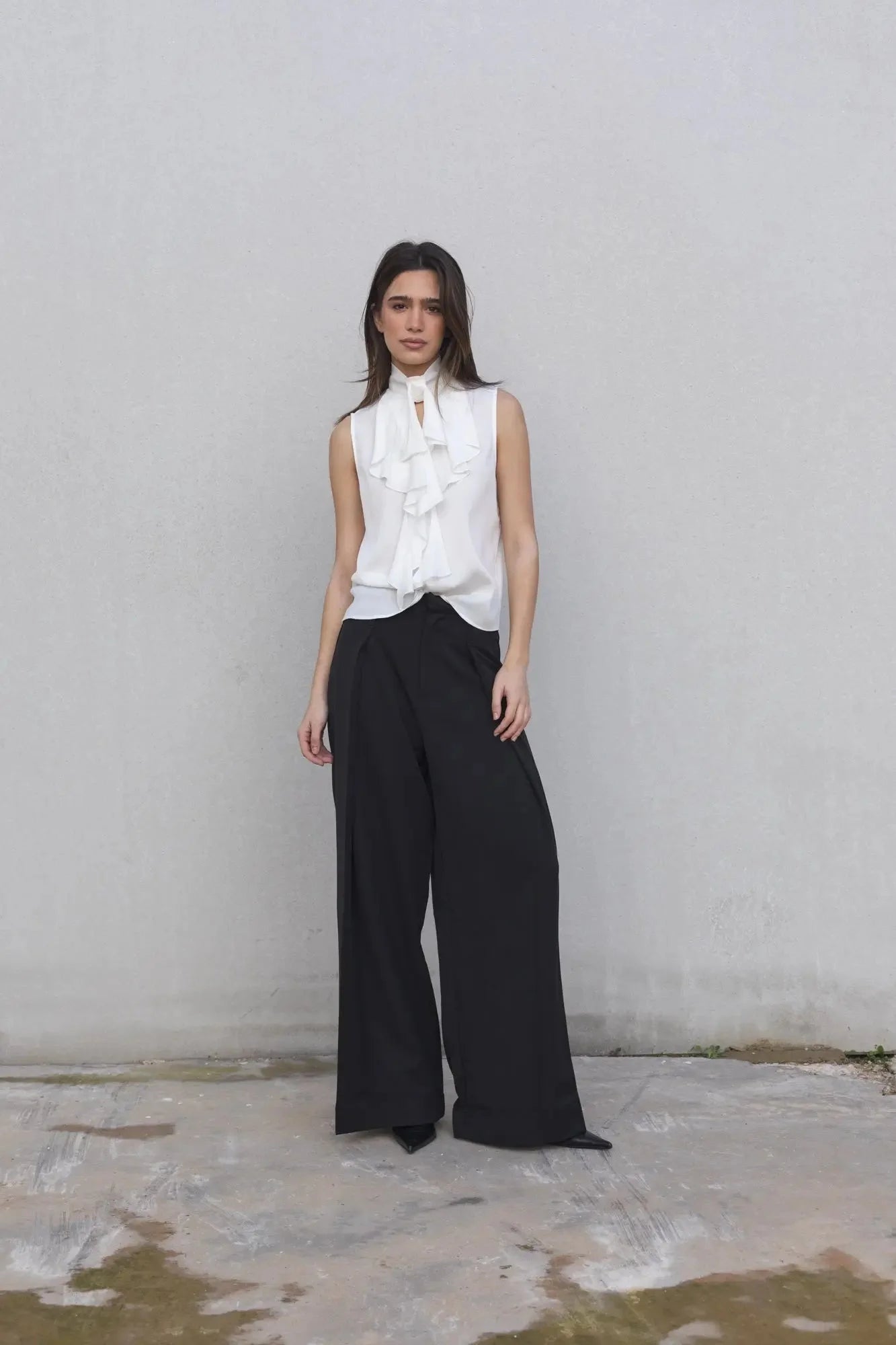 Chemisier blanc lisse à volant sans manches avec pantalon large noir, élégance moderne
