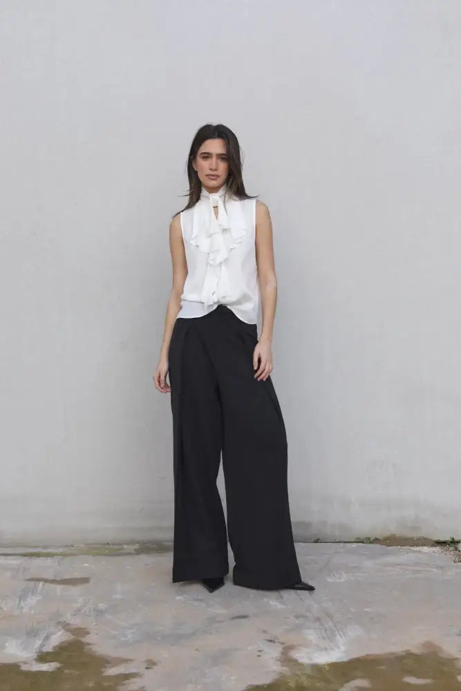 Chemisier blanc lisse à volant sans manches avec pantalon large noir, élégance moderne