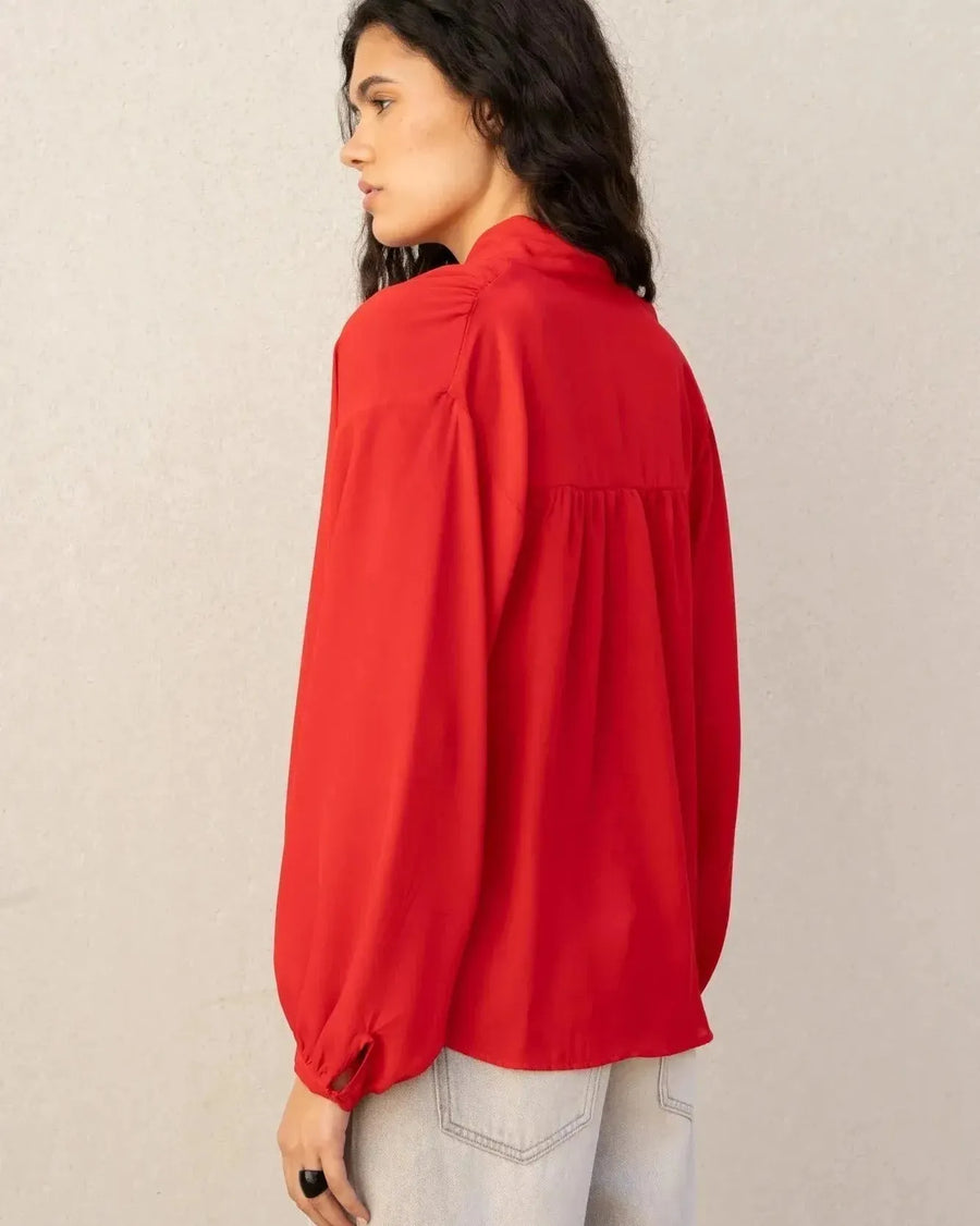 Détail du dos d'un chemisier col lavallière femme rouge fluide à manches longues, montrant la coupe élégante et féminine.