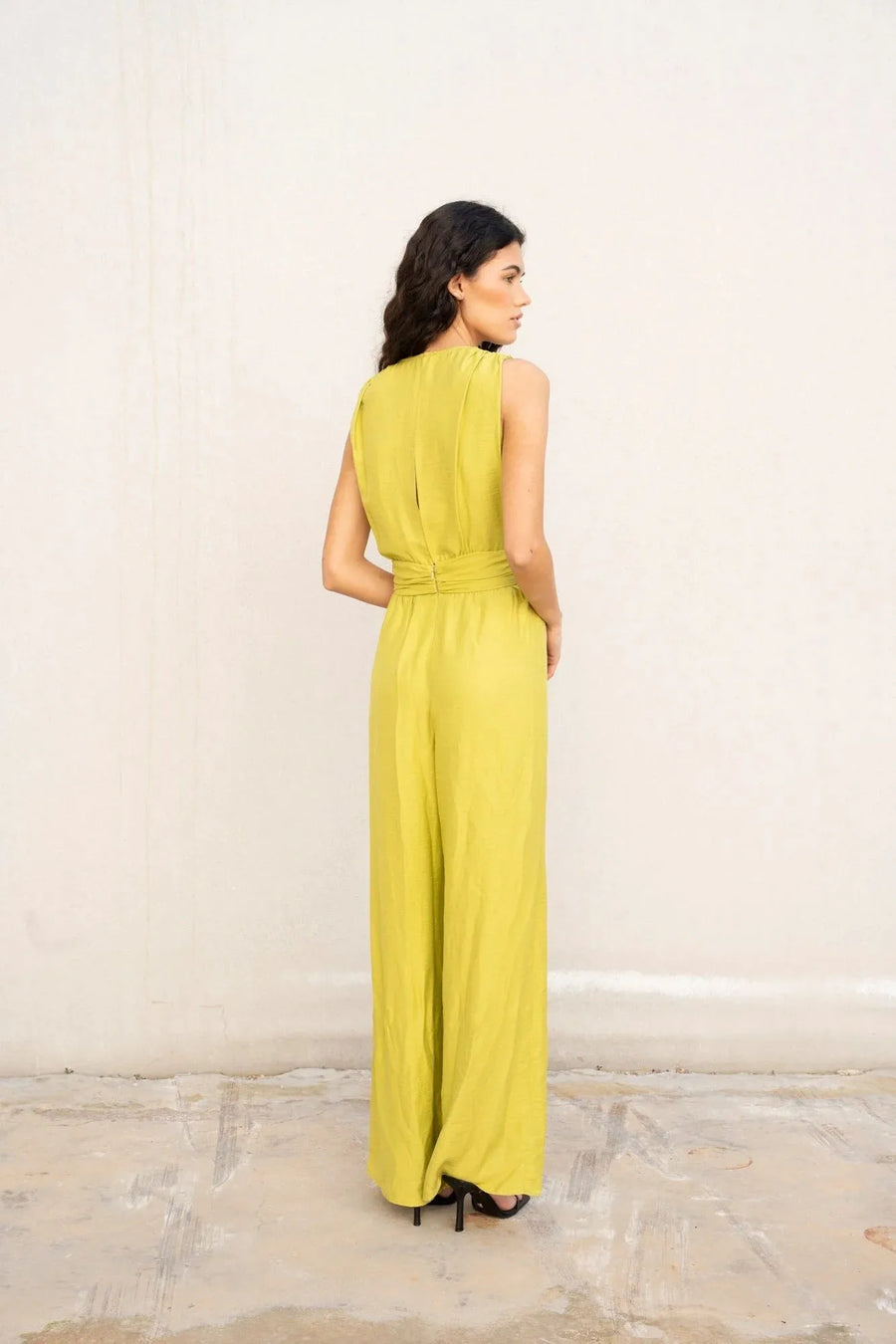 Vue arrière d'une femme en combinaison fluide femme cache-cœur vert citron, combinaison verte femme, dévoilant le design élégant.