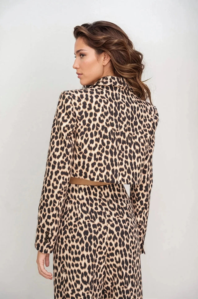 Femme vue de dos en veste blazer leopard femme, style unique avec imprimé animal, devant un fond clair.