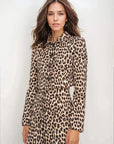 Femme souriante en veste blazer leopard femme, style unique avec imprimé animal, mettant en avant son style moderne.