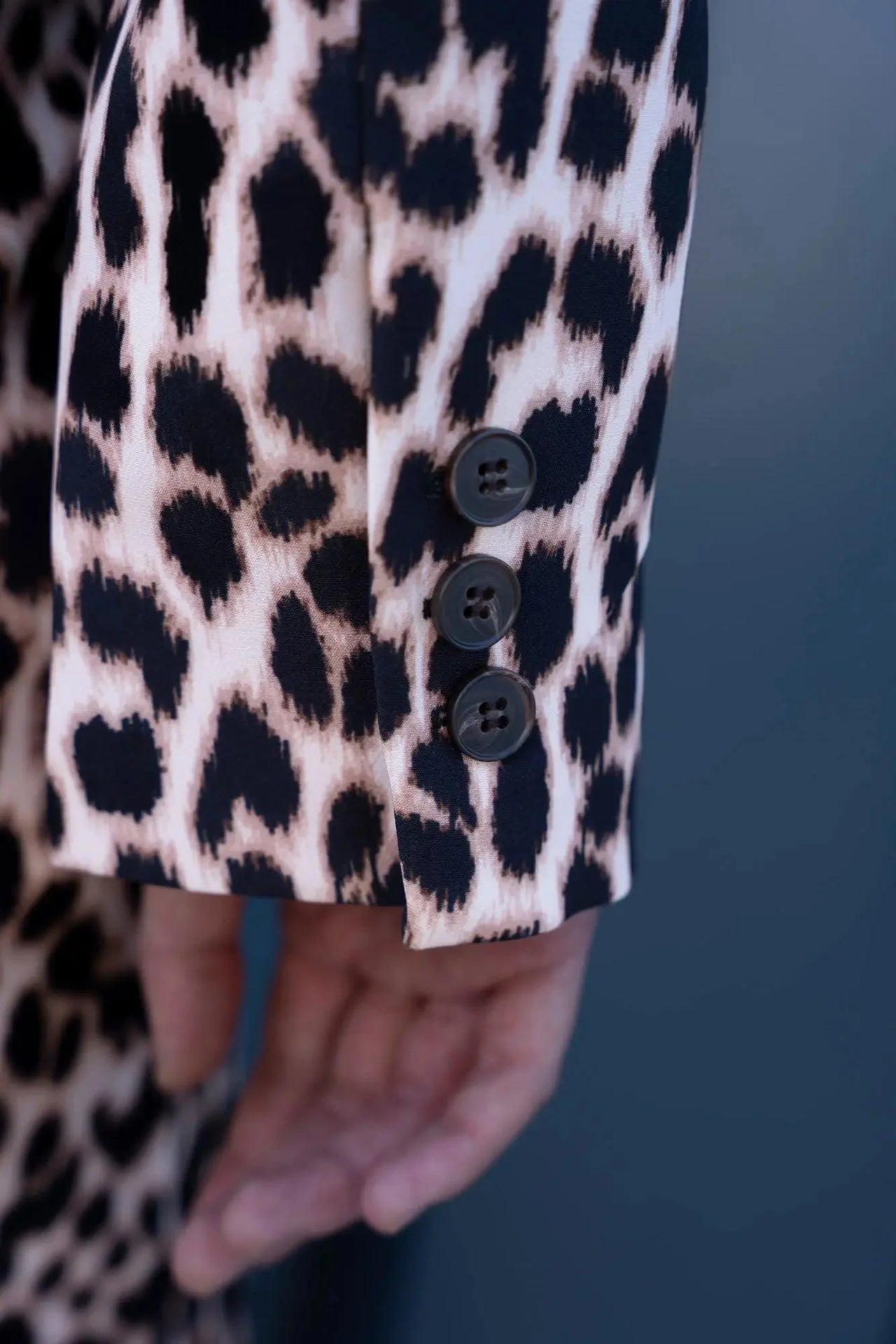 Détail des boutons sur la manche de la veste blazer leopard femme, style unique avec imprimé animal.