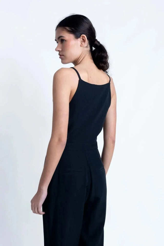 Profil de la combinaison noire femme, révélant la coupe élégante et le dos dégagé, une pièce indispensable pour toute garde-robe.