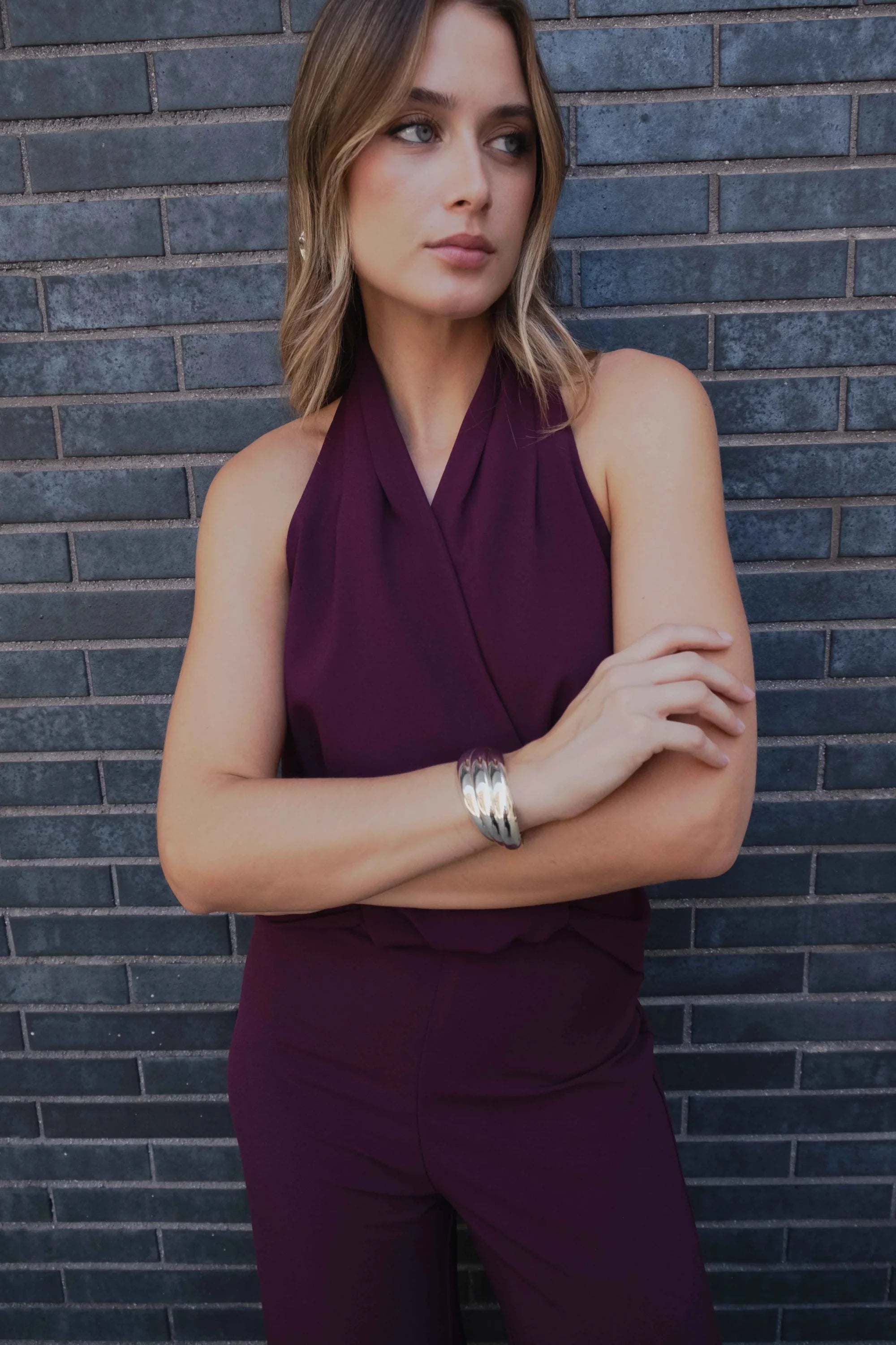 Combinaison pantalon bordeaux prune chic avec col halter et bracelet argenté élégant