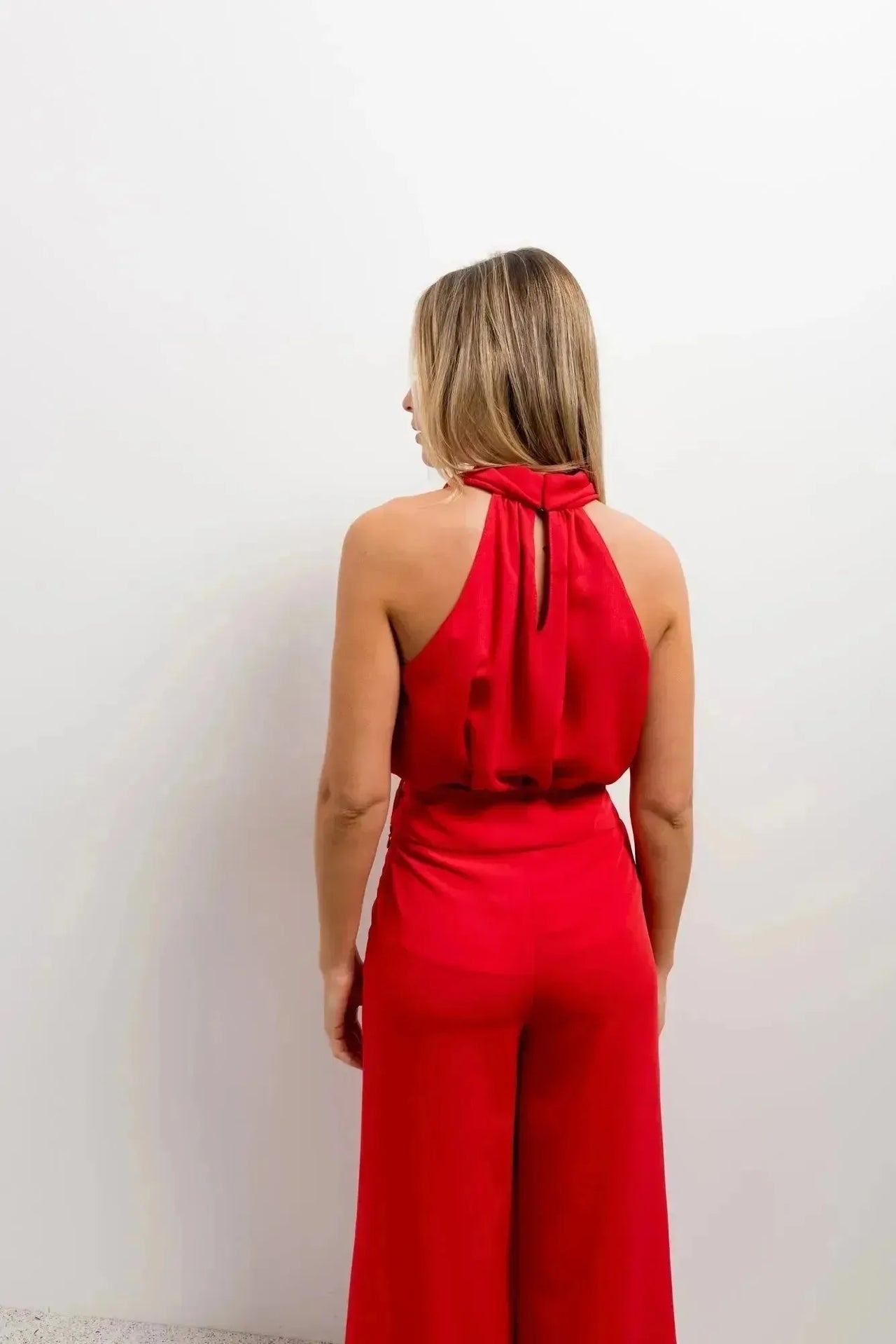 Femme vue de dos portant un pantalon jupe femme rouge éclatant taille haute, confortable et stylé pour une soirée.