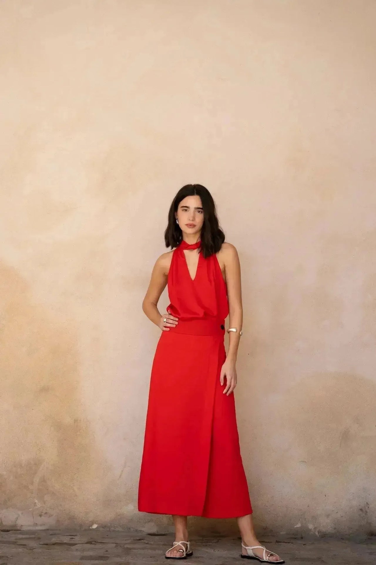 Femme affichant un pantalon jupe femme rouge éclatant taille haute, avec une coupe moderne, idéale pour impressionner lors d'une soirée élégante.