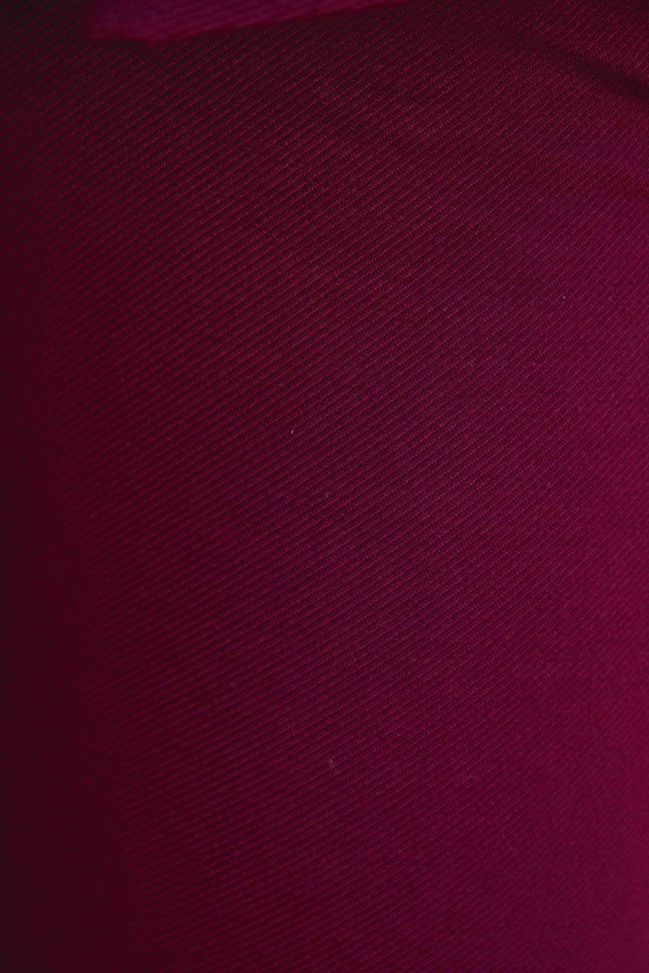 Zoom sur la texture du débardeur tricot femme bordeaux, soulignant le tissu extensible et sophistiqué.